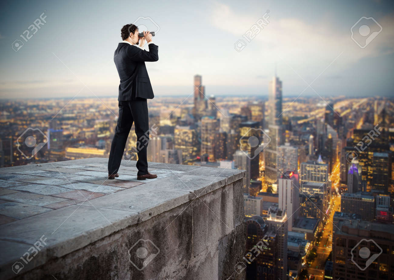 Businessman looks at the city from the roof with binoculars - 63888858 Businessman looks at the city from the roof with binoculars - 63888858