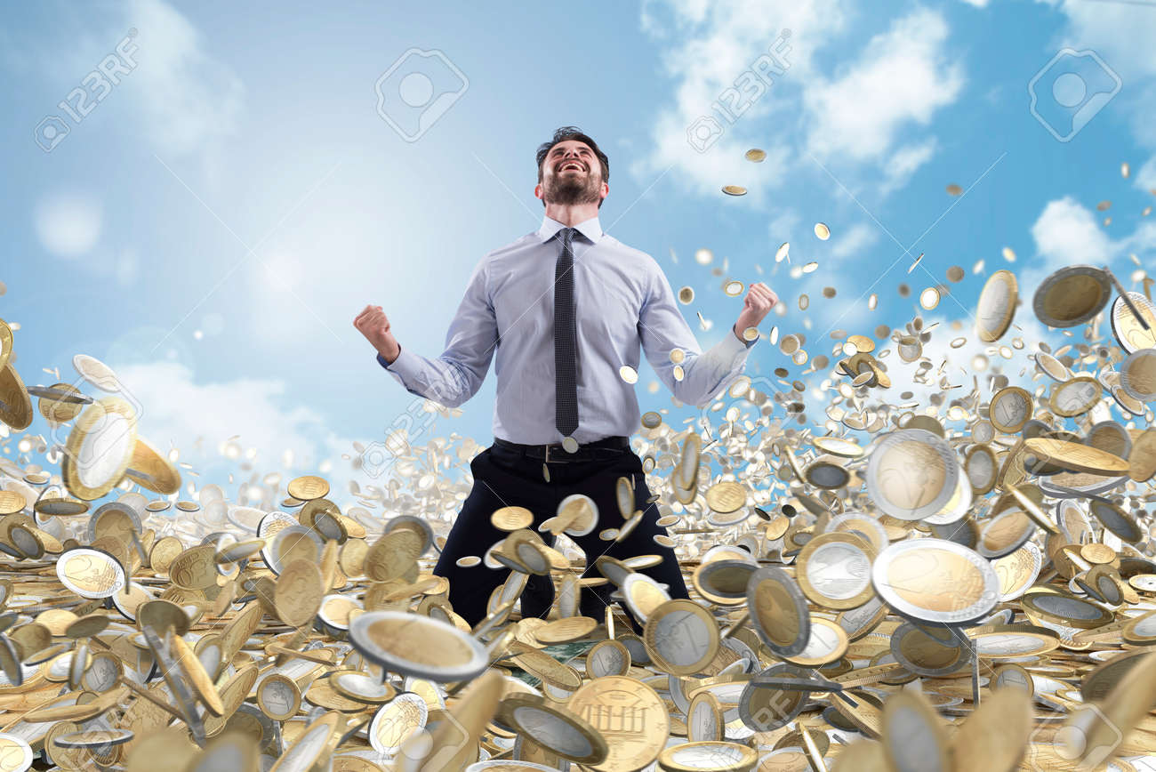 Businessman exults over a lot of money coins - 116758226 Businessman exults over a lot of money coins - 116758226