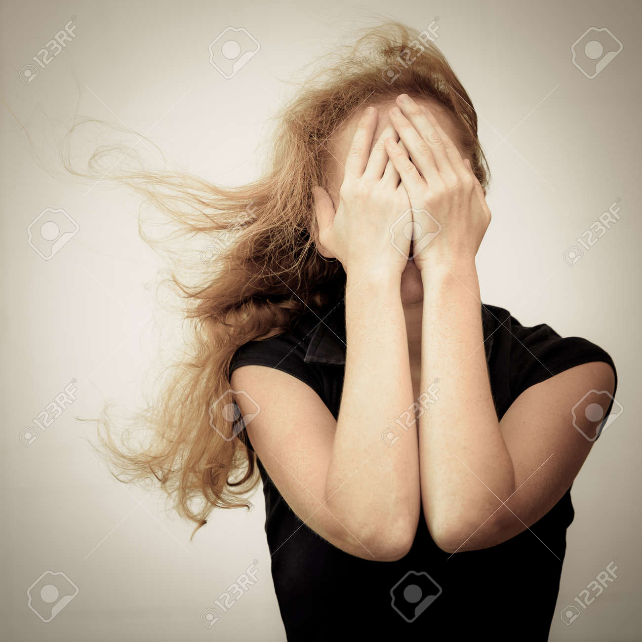 1 つの悲しい女性は壁の近くに立って 彼女の手で彼女の頭を保持 の写真素材 画像素材 Image