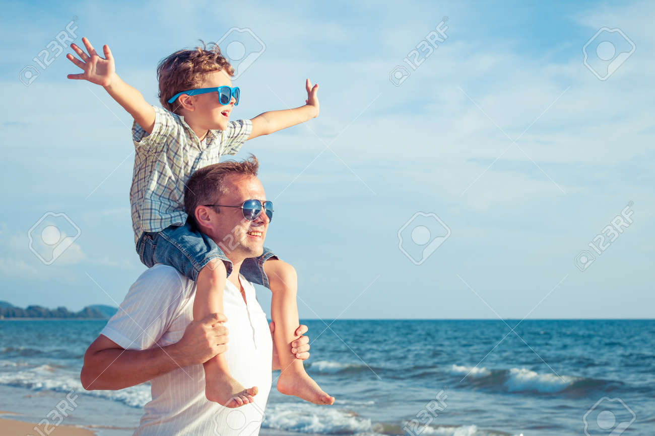 Father and son playing on the beach at the day time. Concept of friendly family. - 51580812 Father and son playing on the beach at the day time. Concept of friendly family. - 51580812