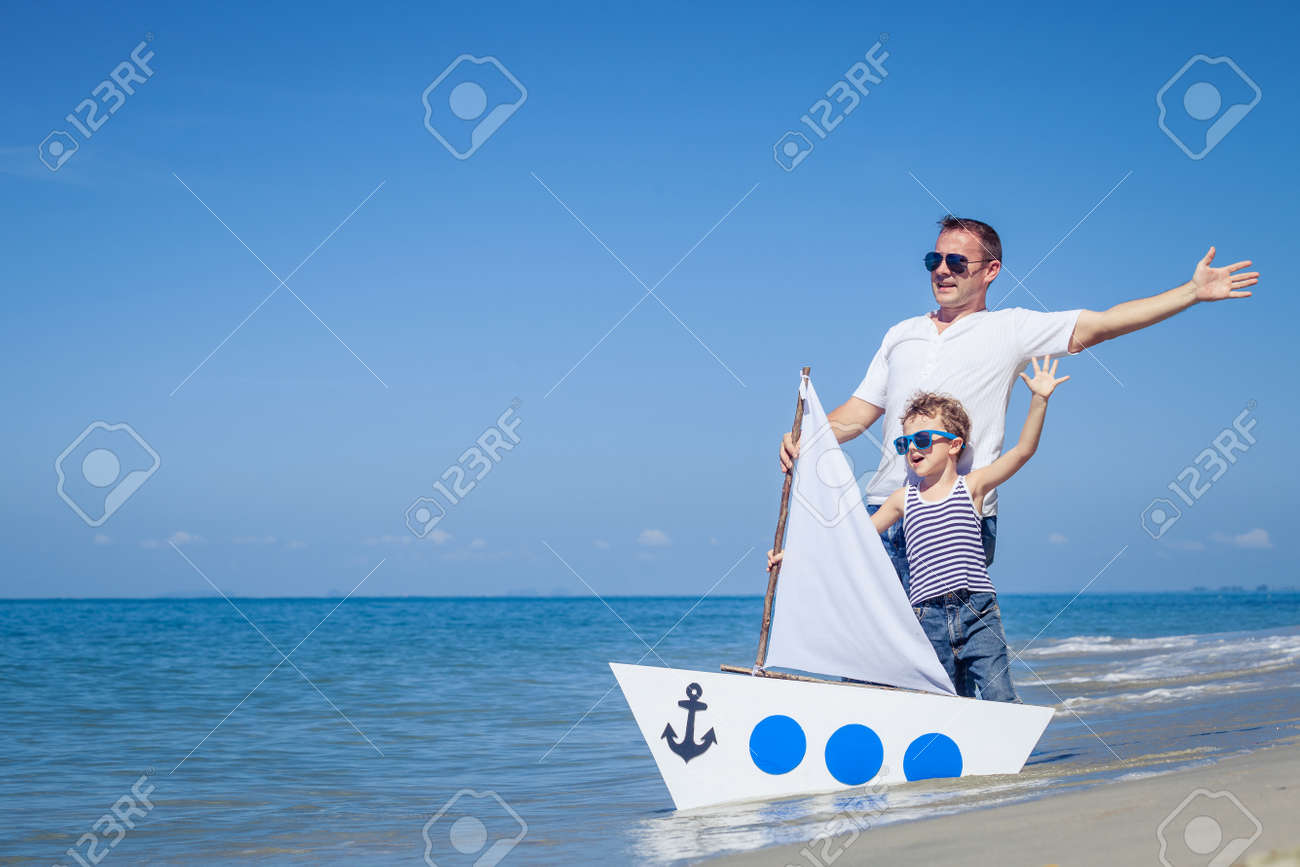 Father and son playing on the beach at the day time. Concept of friendly family. - 52668404 Father and son playing on the beach at the day time. Concept of friendly family. - 52668404