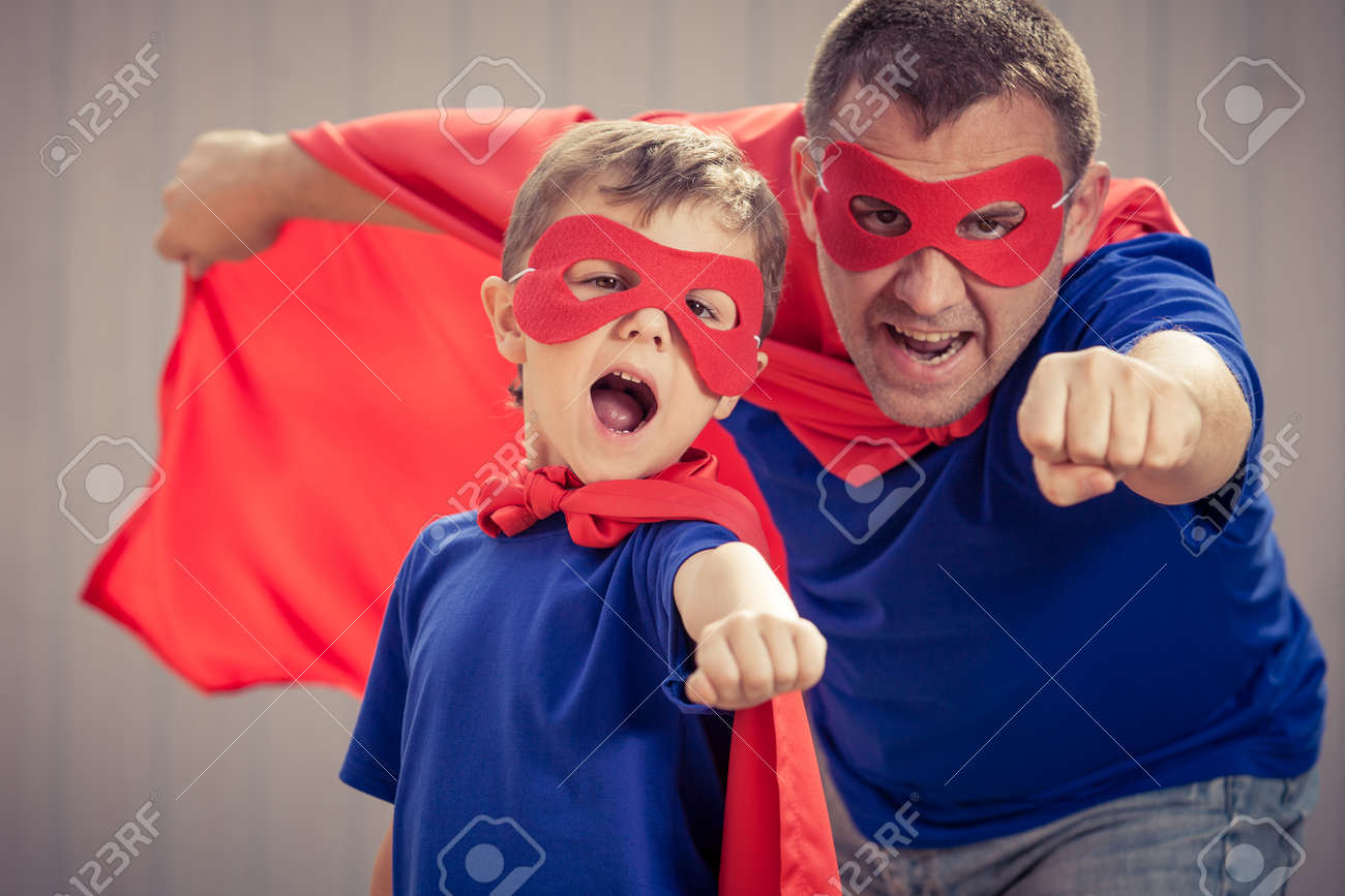 Father and son playing superhero at the day time. People having fun outdoors. Concept of friendly family. - 64435624 Father and son playing superhero at the day time. People having fun outdoors. Concept of friendly family. - 64435624