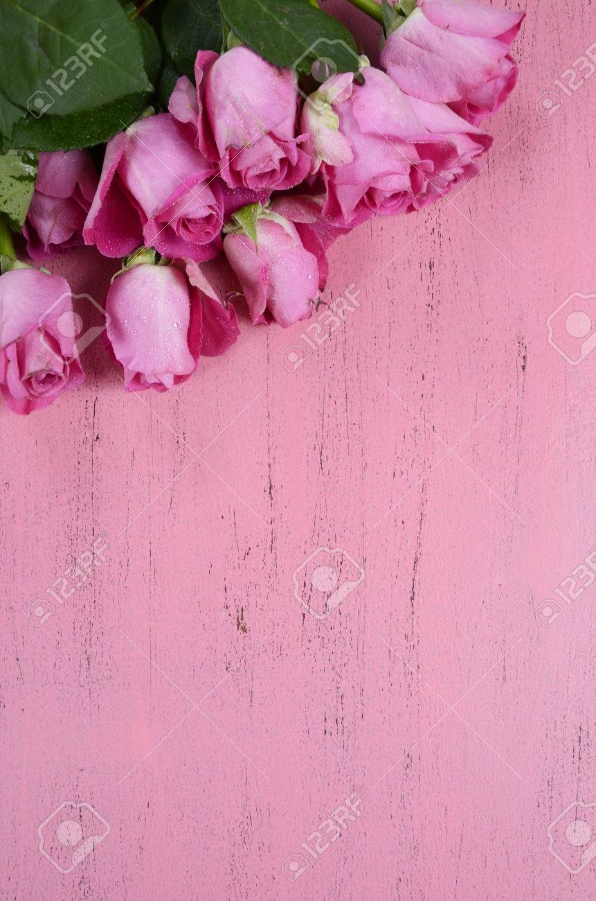 rosas rosadas en el fondo de madera de color rosa vertical con