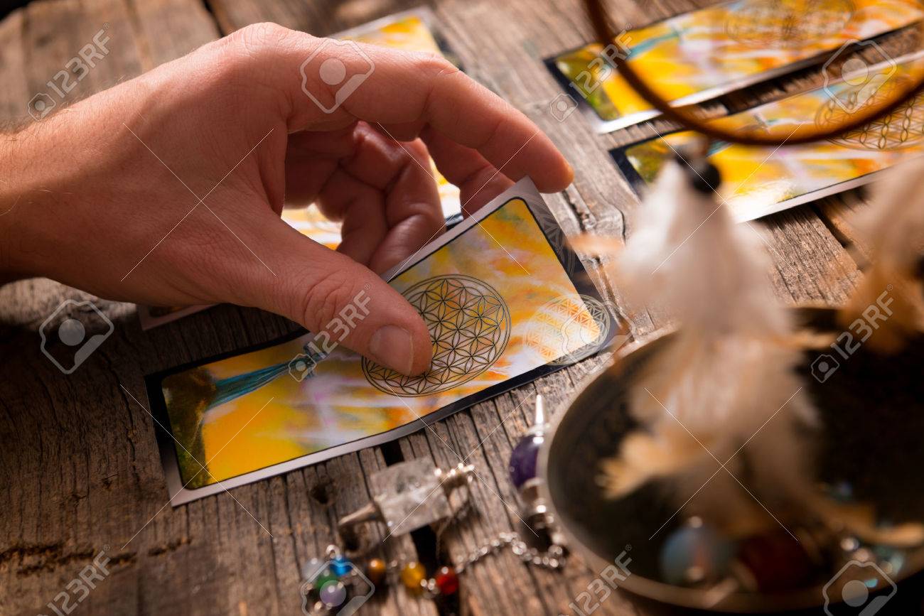 Fortune teller holding a tarot card - 51029175 Fortune teller holding a tarot card - 51029175