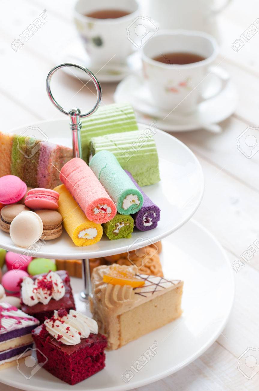 cakes and macaroons on two tiered tray with teapot and cup background - 47440498 cakes and macaroons on two tiered tray with teapot and cup background - 47440498