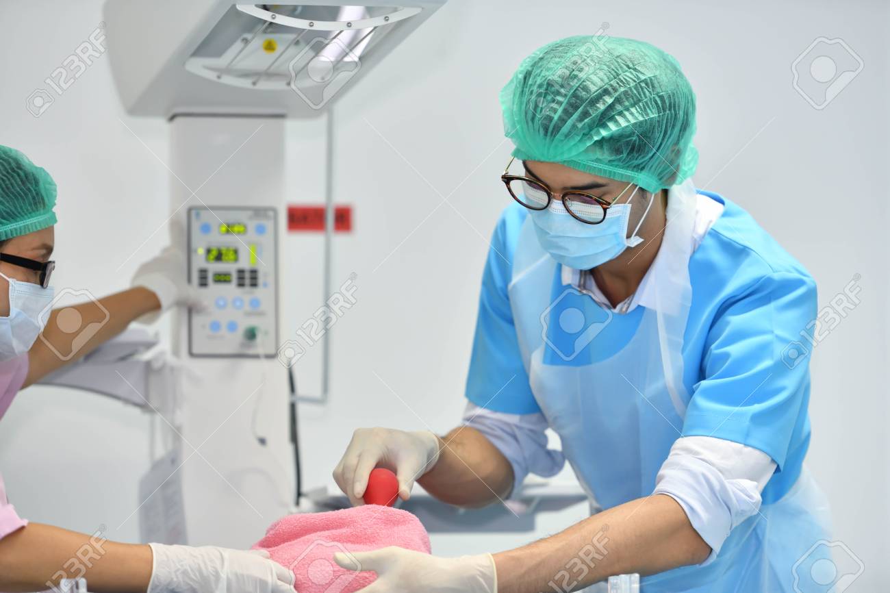 asian male obstetrician and nurse are examining newborn baby stock newborn nurse