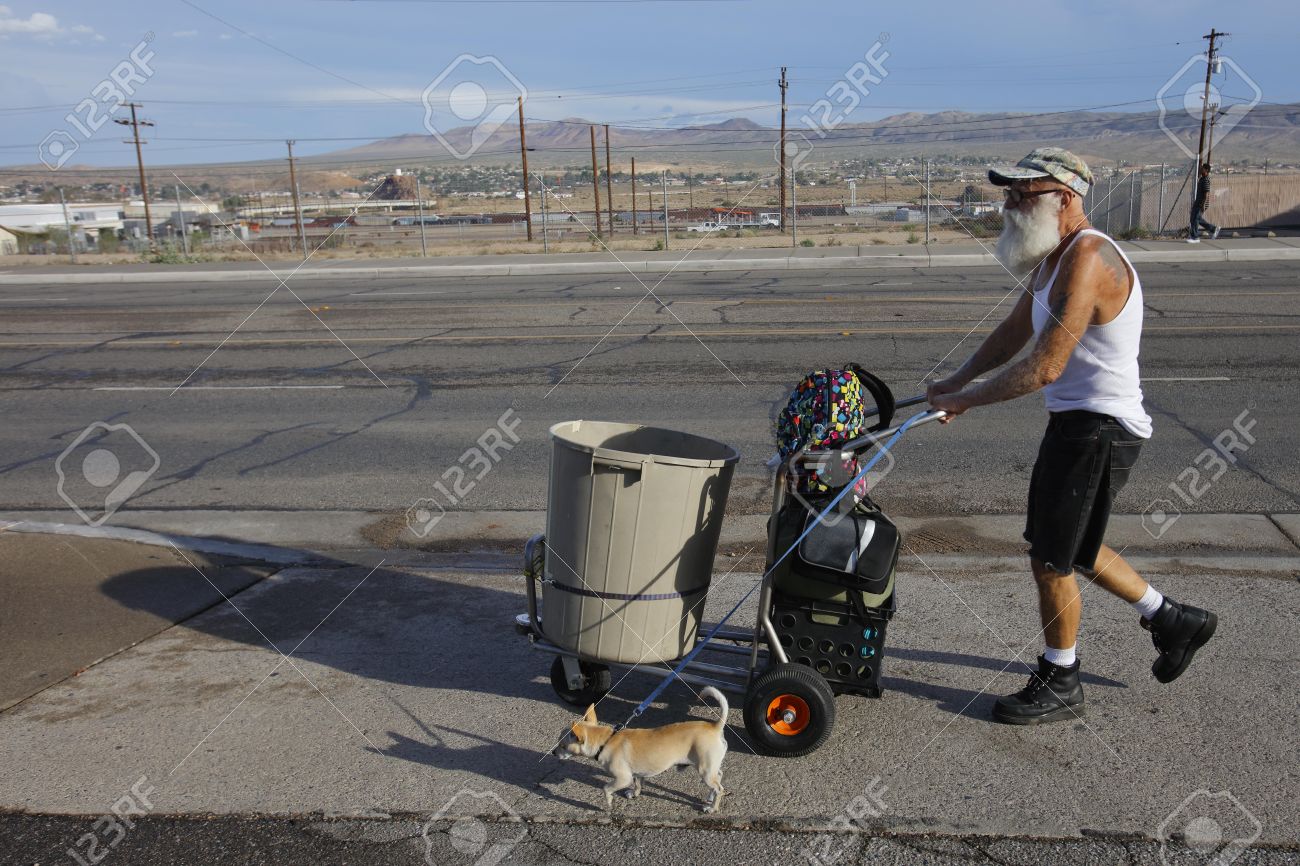 barstow ca homeless man in t shirt and dog pushes a shopping
