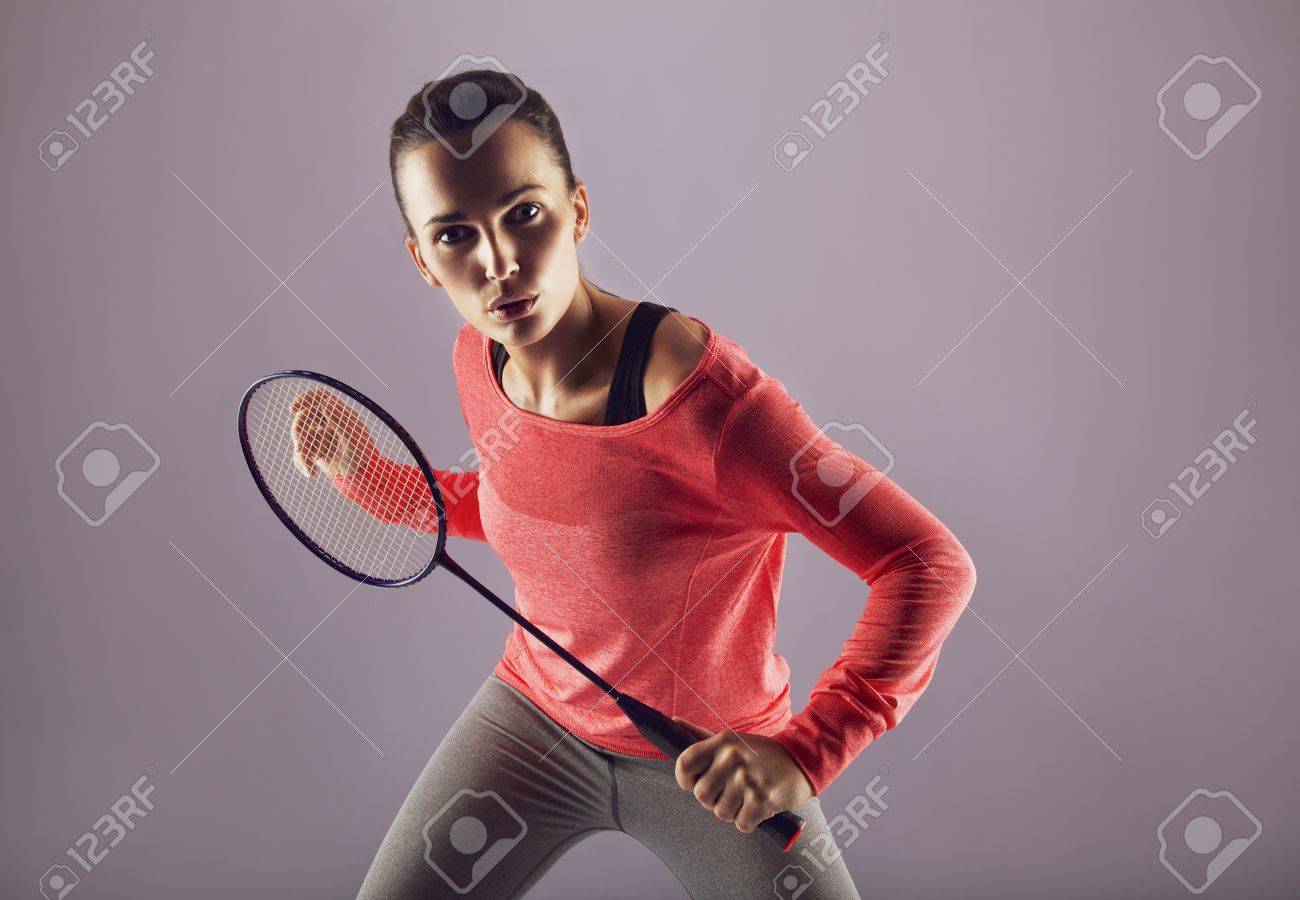 美しい少女は グレーと対戦バドミントン ラケットを保持しています 女性のスポーツは人のバドミントンのプレーヤー カメラ目線します の写真素材 画像素材 Image