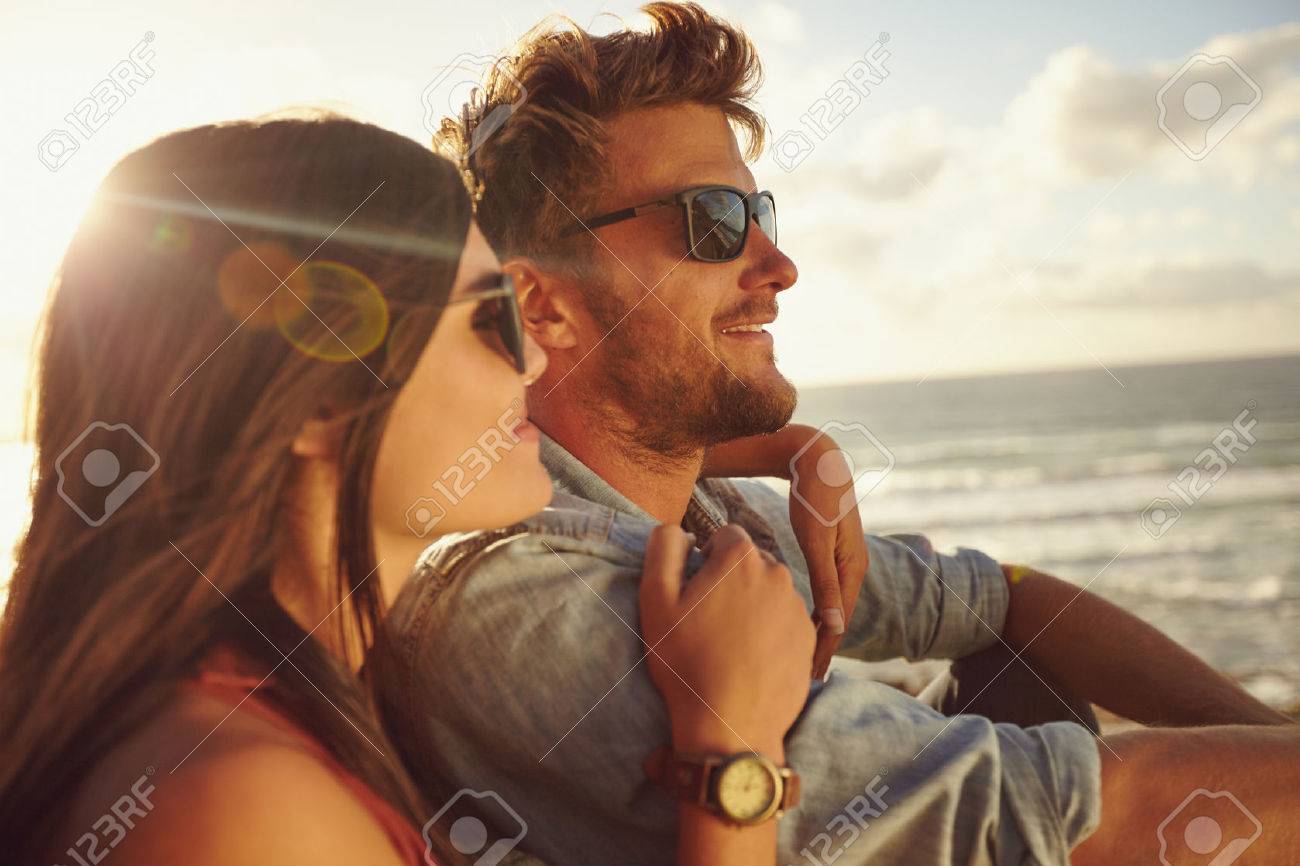 Romantic young couple together outdoors on a summer day. Caucasian couple enjoying the beach view. - 40567880 Romantic young couple together outdoors on a summer day. Caucasian couple enjoying the beach view. - 40567880