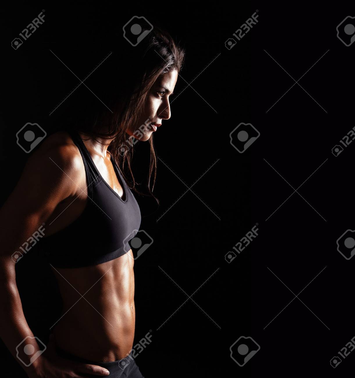 Image of fitness woman in sports clothing looking away on black background. Young female with perfect muscular body. Determination and confidence. - 43375619 Image of fitness woman in sports clothing looking away on black background. Young female with perfect muscular body. Determination and confidence. - 43375619