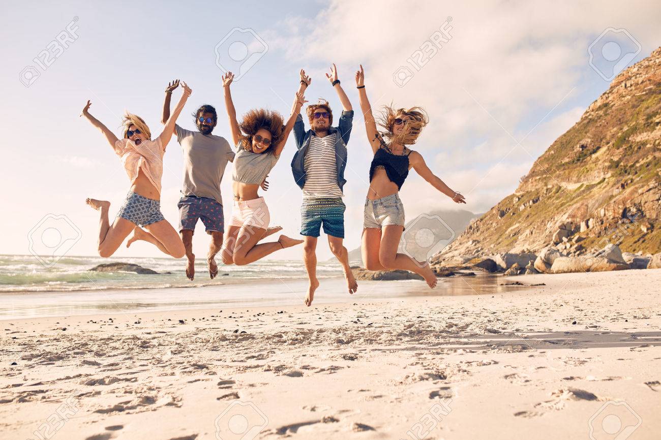 Group of friends together on the beach having fun. Happy young people jumping on the beach. Group of friends enjoying summer vacation on a beach. - 51685898 Group of friends together on the beach having fun. Happy young people jumping on the beach. Group of friends enjoying summer vacation on a beach. - 51685898