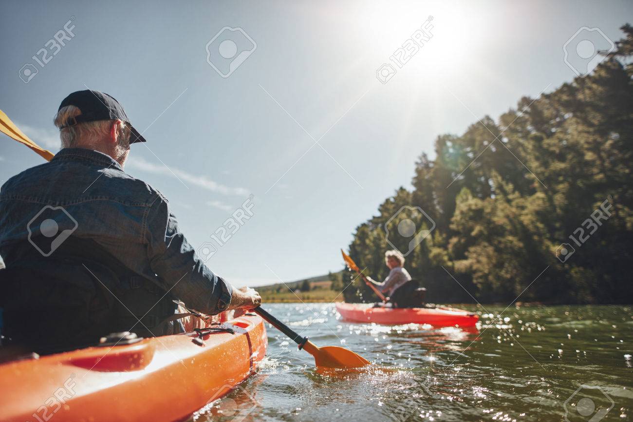 Image of senior couple canoeing in the lake on a sunny day. Kayakers in the lake paddling. - 52328687 Image of senior couple canoeing in the lake on a sunny day. Kayakers in the lake paddling. - 52328687
