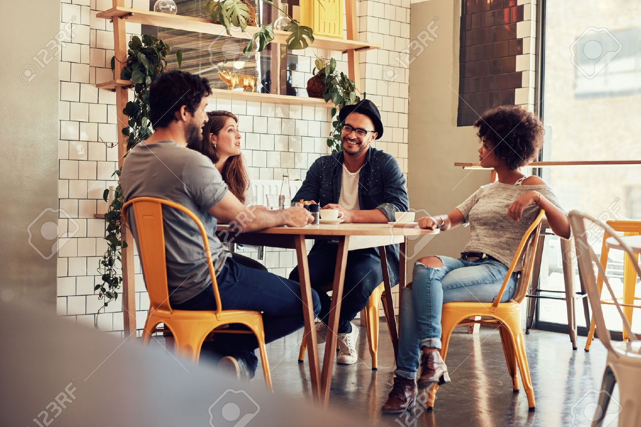 Young People Sitting At A Cafe Table Group Of Friends Talking Stock Photo Picture And Royalty Free Image Image 52549155