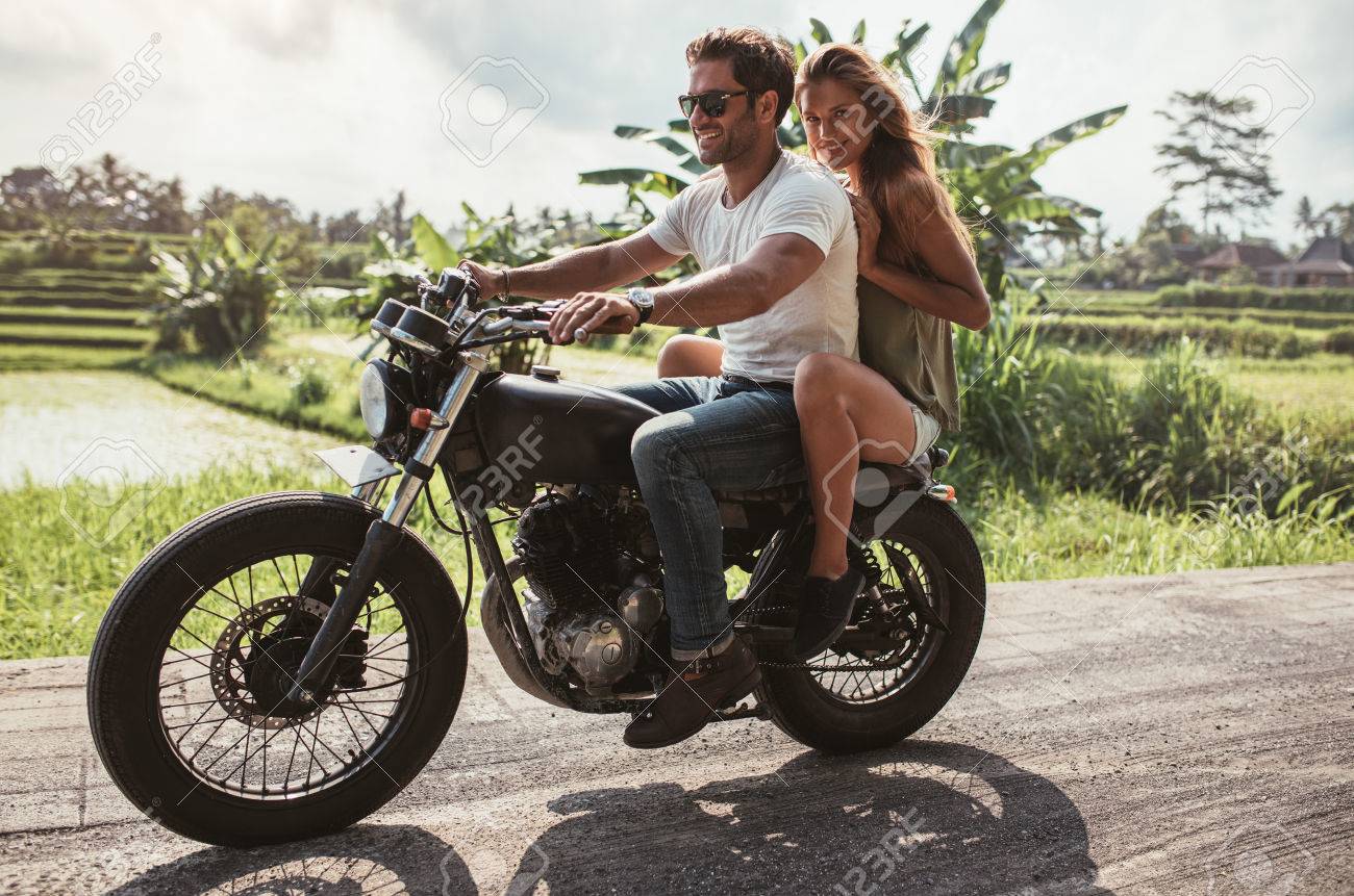 オートバイを楽しんで幸せな若いカップルの屋外撮影は 国の道路に乗る 男と女の夏の日にバイクに乗る の写真素材 画像素材 Image