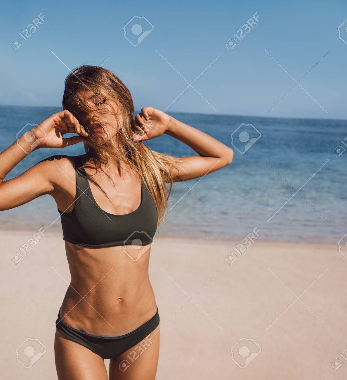 官能的なビキニで浜に立ってモデルの肖像画 セクシーな若い女性が浜辺で水着でポーズします の写真素材 画像素材 Image