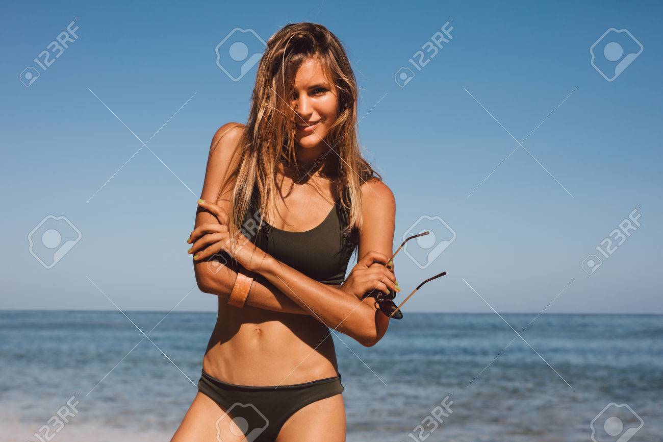 ビーチでビキニの女性モデルのポートレート 海岸で水着でポーズをとって幸せな若い女 の写真素材 画像素材 Image