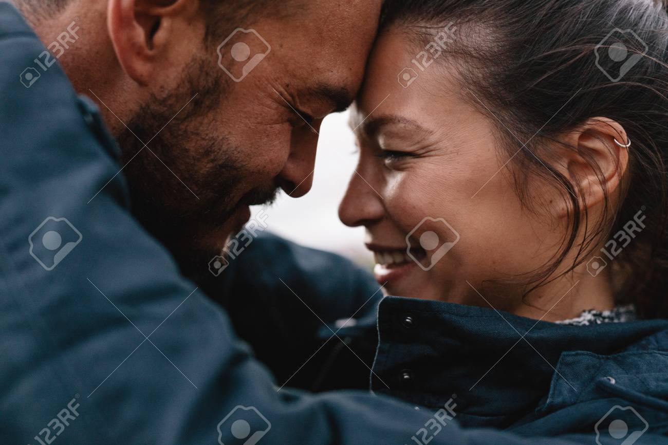 Close-up side portrait of young mixed race couple in love. Romantic couple embracing each other and smiling. - 77980639 Close-up side portrait of young mixed race couple in love. Romantic couple embracing each other and smiling. - 77980639