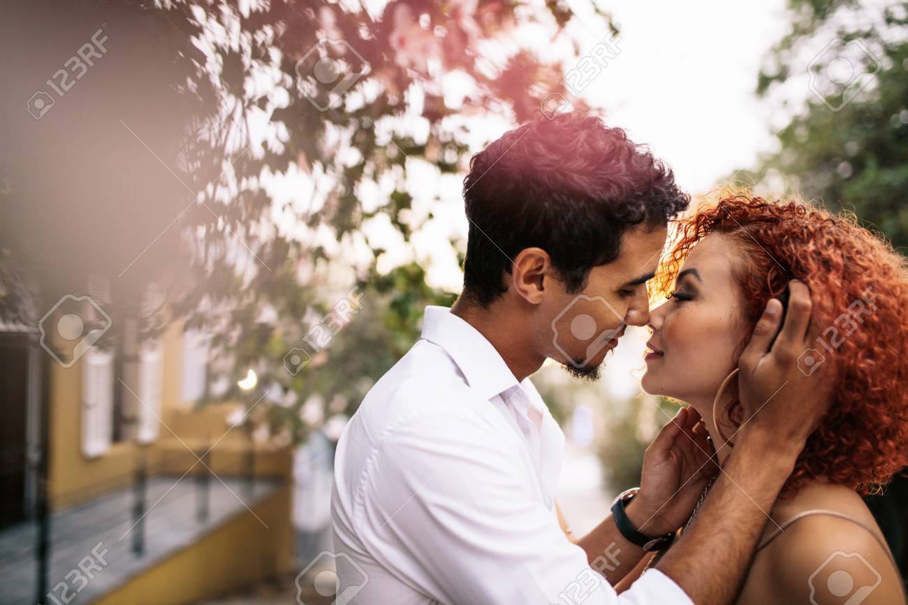 若いカップルがキスをする官能的なポーズでのクローズ アップ 通りに髪を触る女の近くに密接に男 の写真素材 画像素材 Image