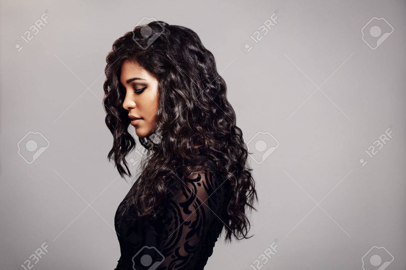 Side View Of Attractive Young Woman With Curly Hair Standing