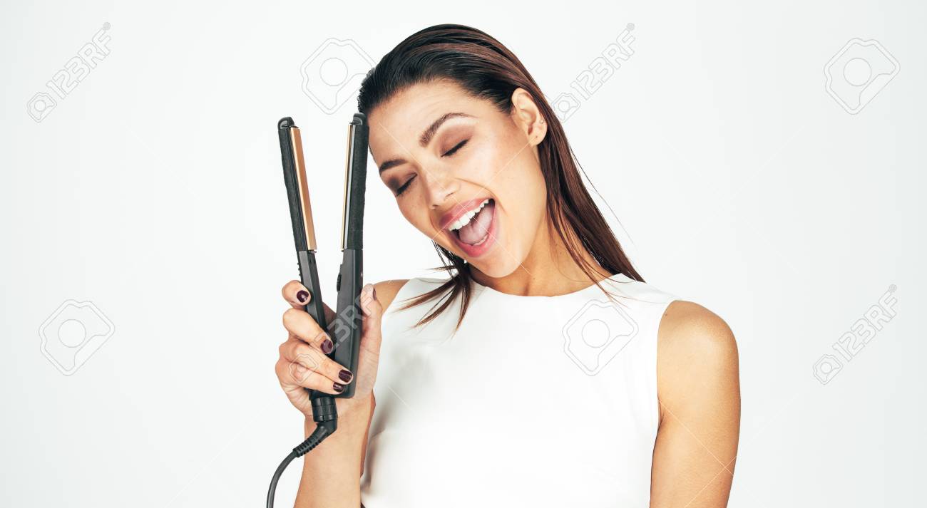 Woman With Eyes Closed Holding A Hair Straightener Close To Her Stock Photo Picture And Royalty Free Image Image 91513091