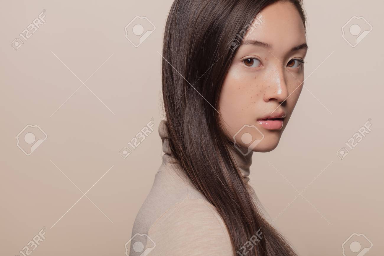 Portrait of woman with straight brown hair. Asian woman with a long hair looking at camera. - 122865699 Portrait of woman with straight brown hair. Asian woman with a long hair looking at camera. - 122865699