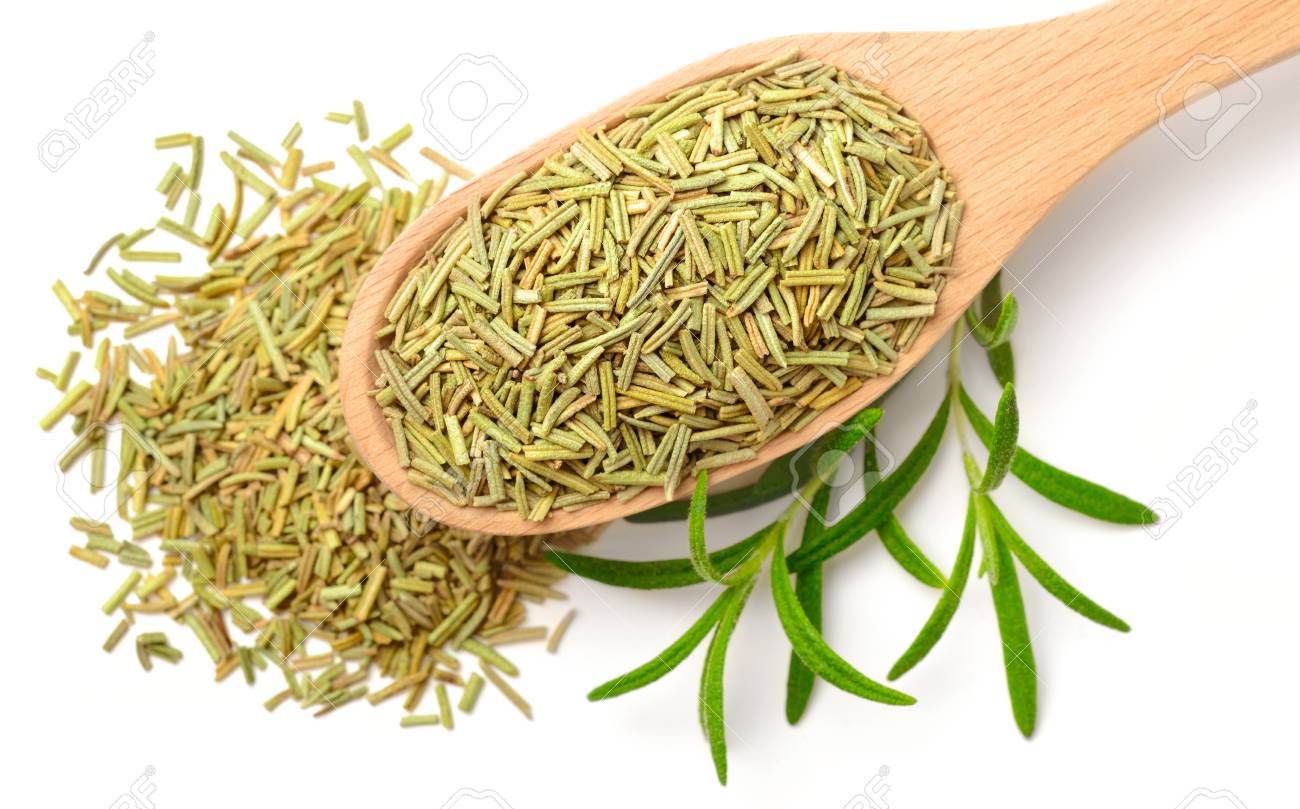dried herbs dried rosemary leaves in the wooden spoon isolated
