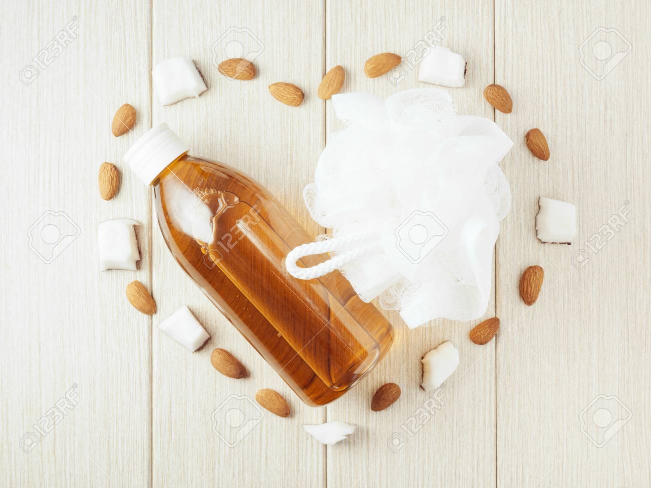 Composition with plastic bottle and mesh shower sponge for body care and beauty products. Beautiful background with almond and coconut. - 112033054 Composition with plastic bottle and mesh shower sponge for body care and beauty products. Beautiful background with almond and coconut. - 112033054
