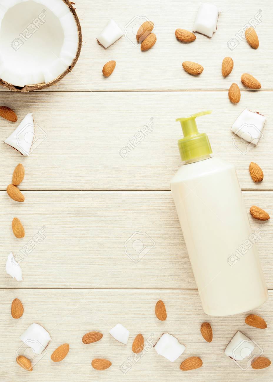Composition with plastic bottle and mesh shower sponge for body care and beauty products. Beautiful background with almond and coconut. - 116643524 Composition with plastic bottle and mesh shower sponge for body care and beauty products. Beautiful background with almond and coconut. - 116643524
