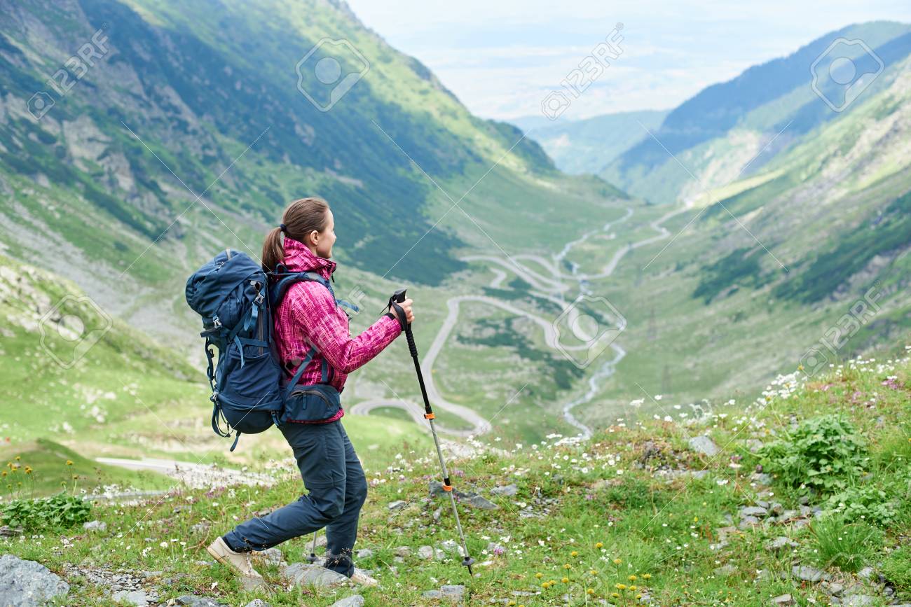 Hiking Trip In The Mountains Of Romania Girl With A Backpack And Trekking Sticks On A Blurred Background Of A Picturesque Landscape Most Beautiful Road In Europe Transfagarashan Highway Stock Photo Hiking Trip In The Mountains Of Romania Girl With A Backpack And Trekking Sticks On A Blurred Background Of A Picturesque Landscape Most Beautiful Road In Europe Transfagarashan Highway Stock Photo