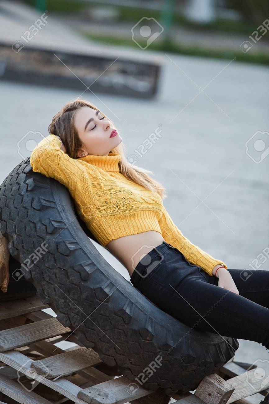 Portrat Ein Schones Sexy Madchen Blond Eine Junge Frau Die Aussieht Wie Jennifer Aniston Liegt In Den Ruinen Ein Grosses Gummirad Vom Traktor Licht Gegen Die Sonne Rote Lippen Lizenzfreie Fotos Bilder