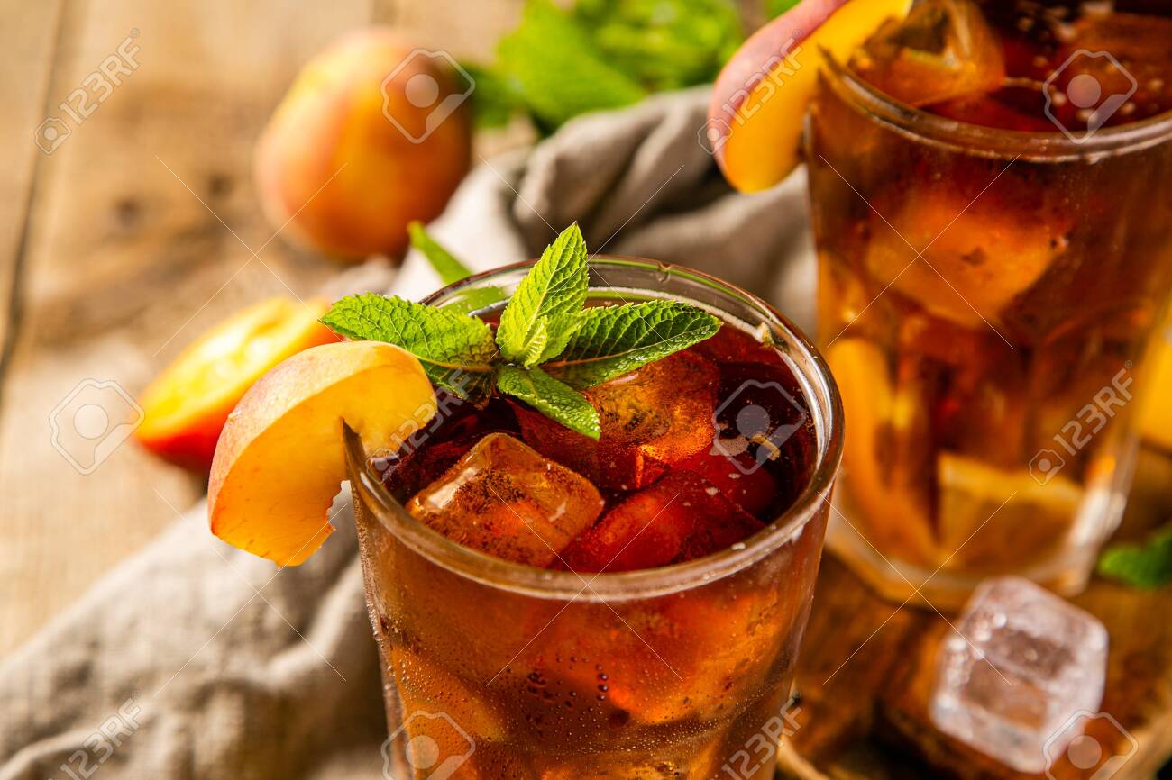 Lemon and peach iced tea on wooden background - 125133054 Lemon and peach iced tea on wooden background - 125133054