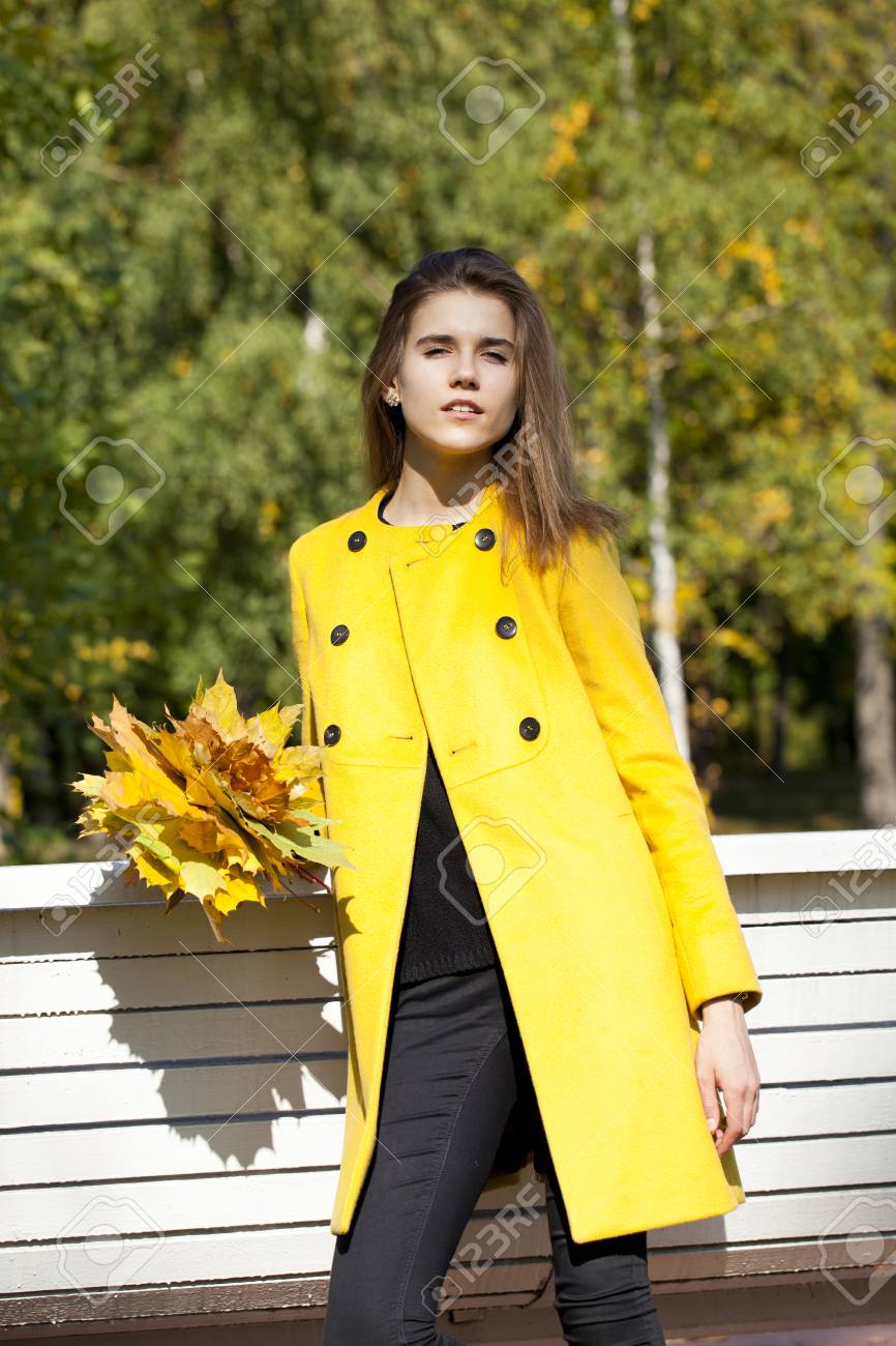 通り秋に黄色のコートで美しい若い女性 の写真素材 画像素材 Image