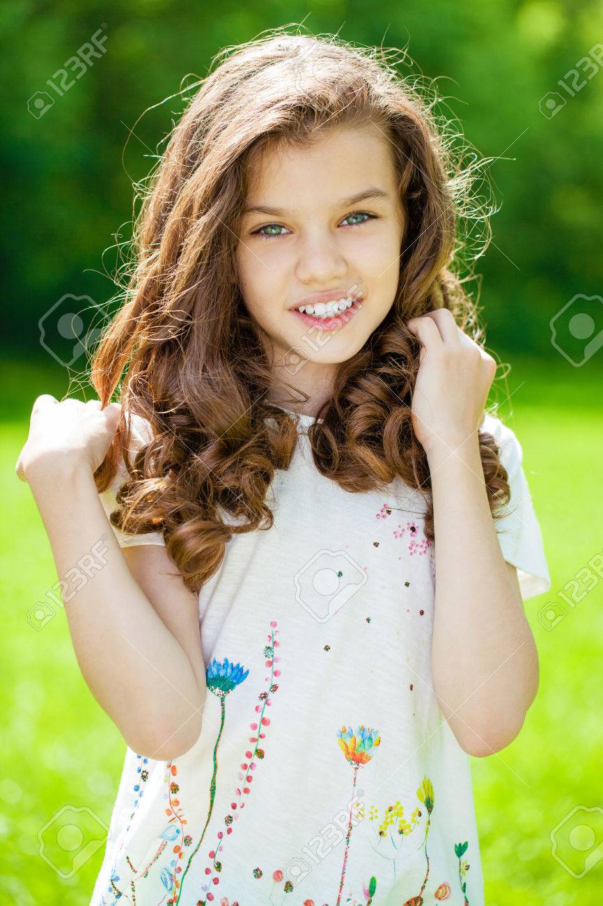 Portrait Of A Beautiful Young Little Girl On The Background Of Summer Park  Stock Photo, Picture and Royalty Free Image. Image 82560474.