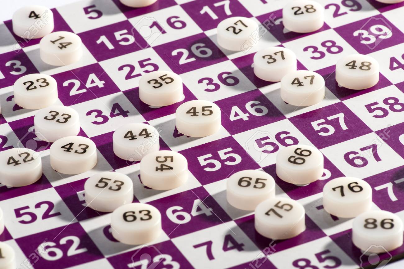 白と紫のビンゴのゲームのカードの上に白いプラスチックのビンゴの番号を閉じる の写真素材 画像素材 Image 3733
