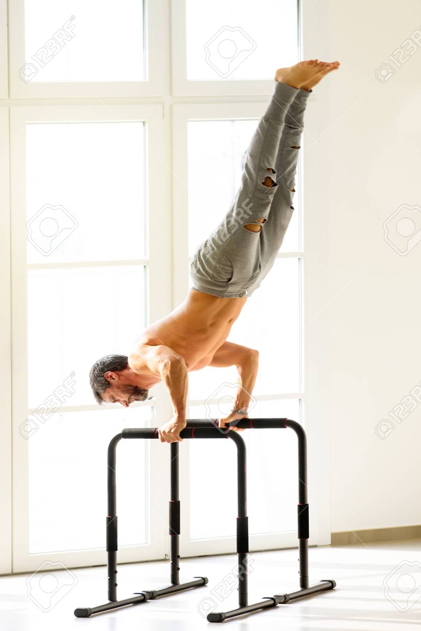 Shirtless Muscular Sportive Man Doing Handstand Push Ups On Bars.. Stock Photo, Picture And Royalty Free Image. Image 140908060.