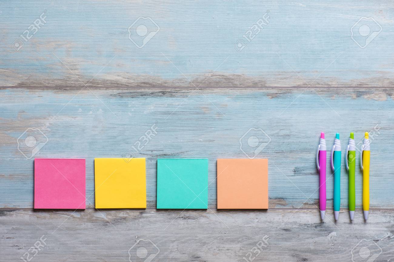 retro blue wooden table with empty colorful sticky notes and stock
