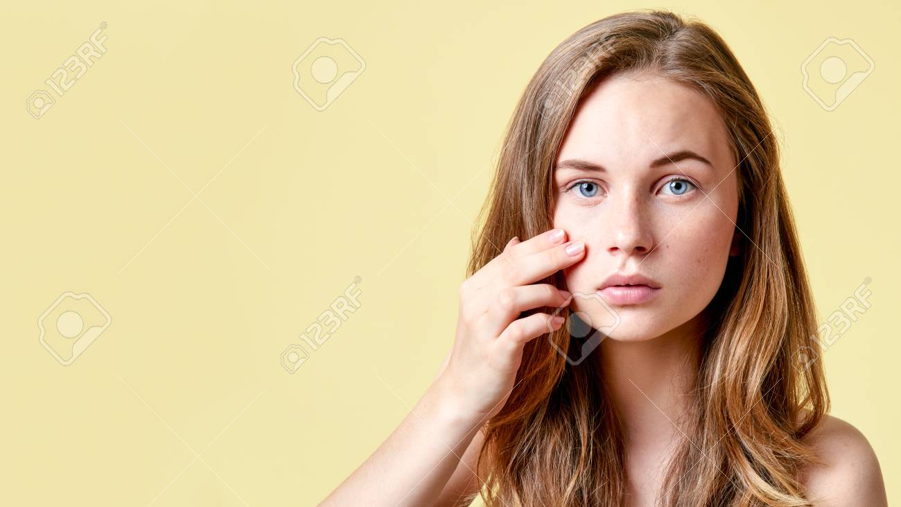 Young redhead teenager with self issues looking into mirror. Girl with low self esteem checking her skin in a mirror. - 92940994 Young redhead teenager with self issues looking into mirror. Girl with low self esteem checking her skin in a mirror. - 92940994