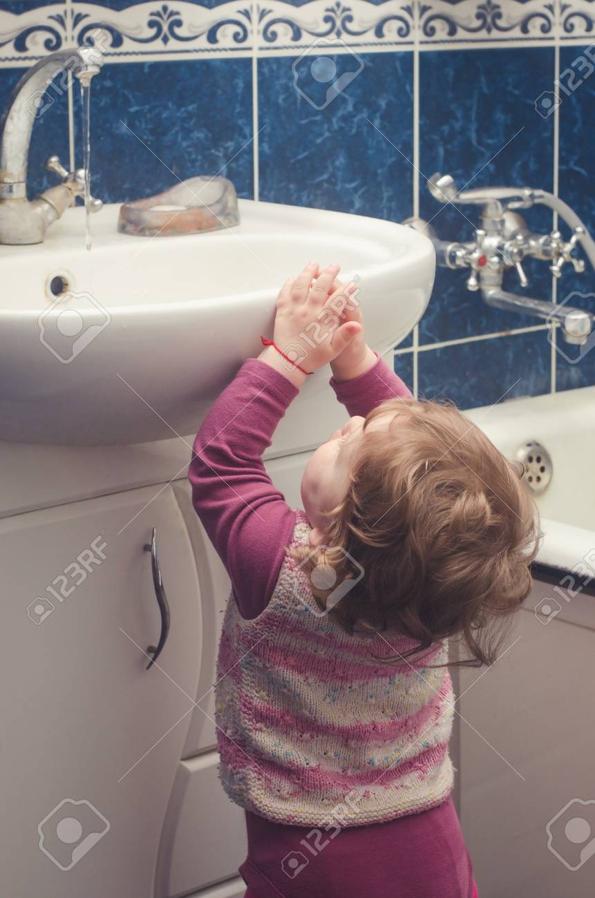 少女は浴室の流しのために達する の写真素材 画像素材 Image 少女は浴室の流しのために達する の写真素材 画像素材 Image