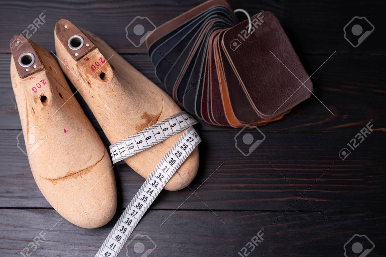 Leather samples for shoes and wooden shoe last on dark wooden table. Designer furniture clothes. Shoe maker workspace. - 148590705 Leather samples for shoes and wooden shoe last on dark wooden table. Designer furniture clothes. Shoe maker workspace. - 148590705