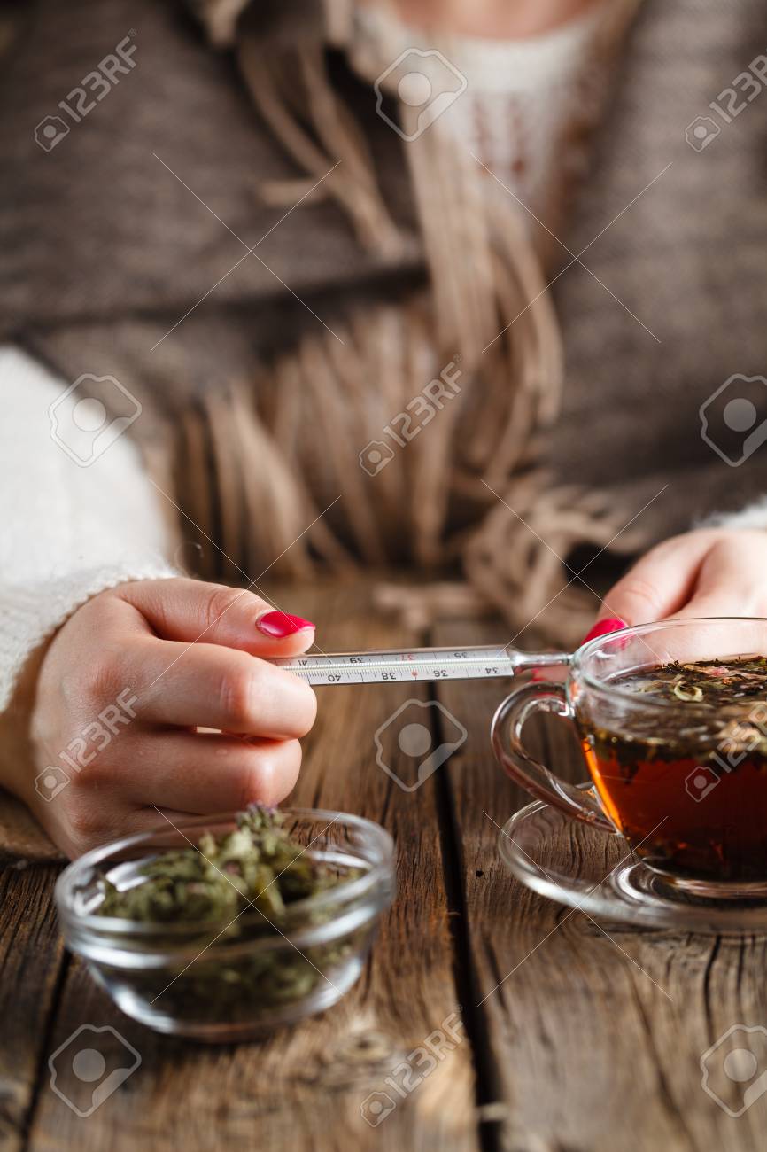 発熱に対して熱いお茶 女性に見えます温度温度計と飲むハーブティーに蜂蜜と の写真素材 画像素材 Image