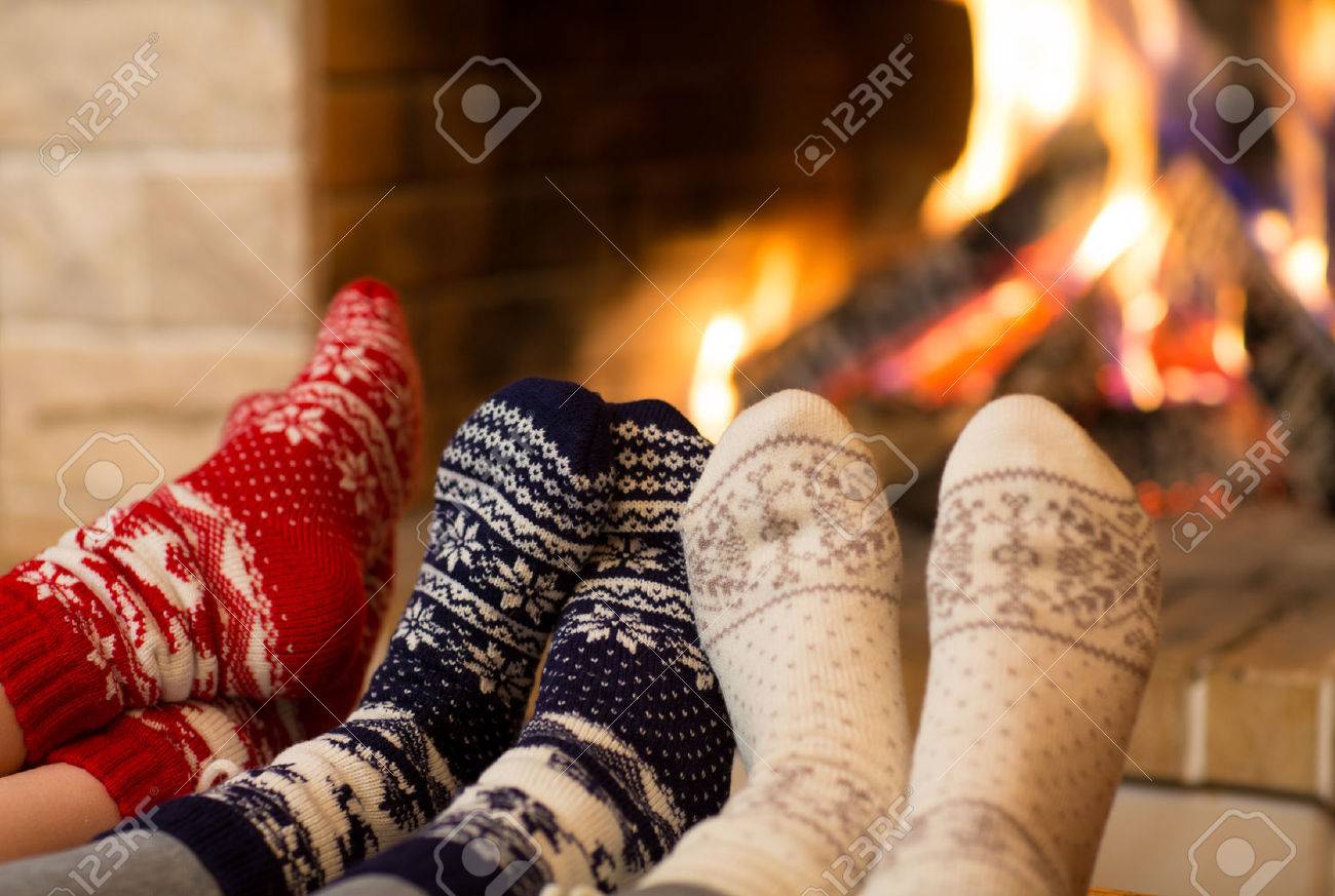 Feet in wool socks near fireplace in winter time - 49176722 Feet in wool socks near fireplace in winter time - 49176722