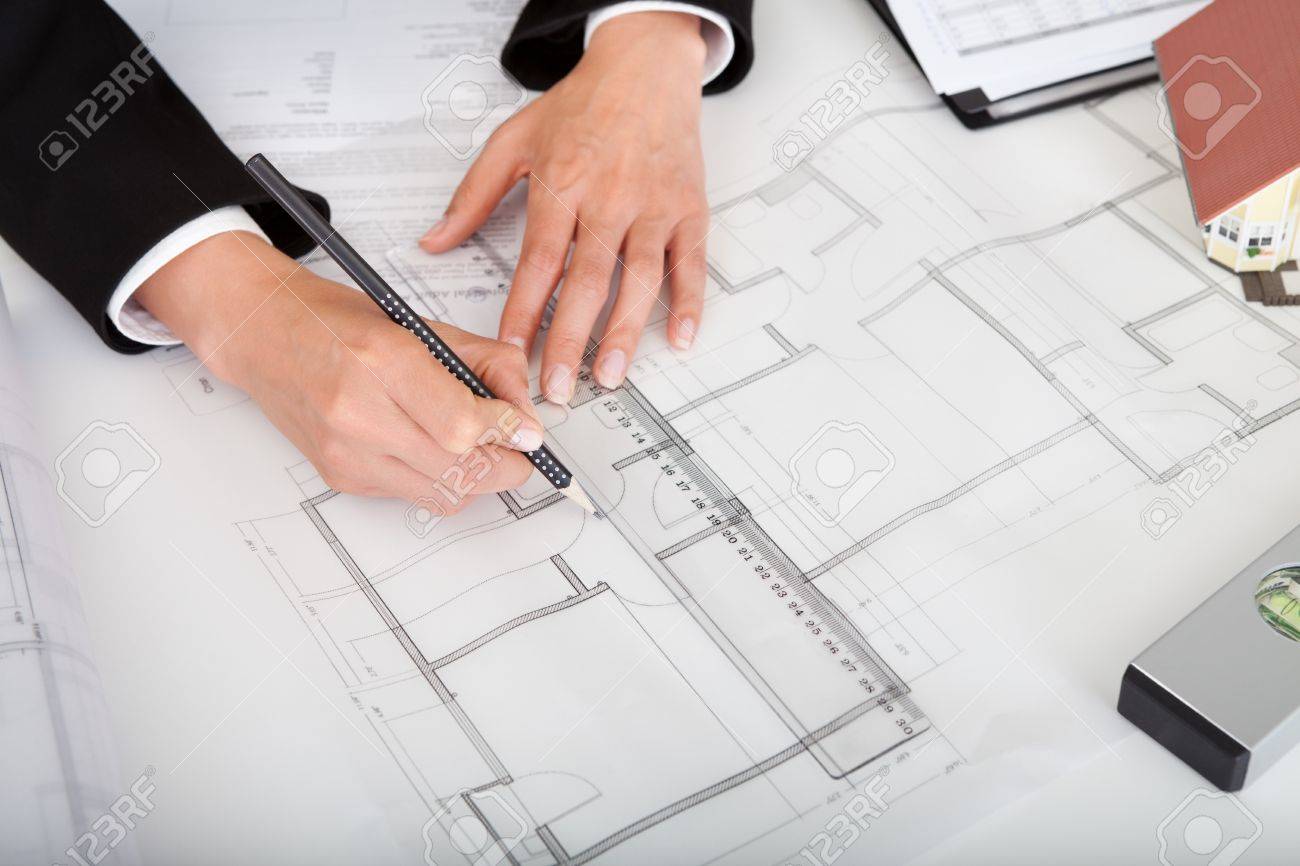 Architect Desk midsection of female architect with model house, blueprints and Architect Desk midsection of female architect with model house, blueprints and
