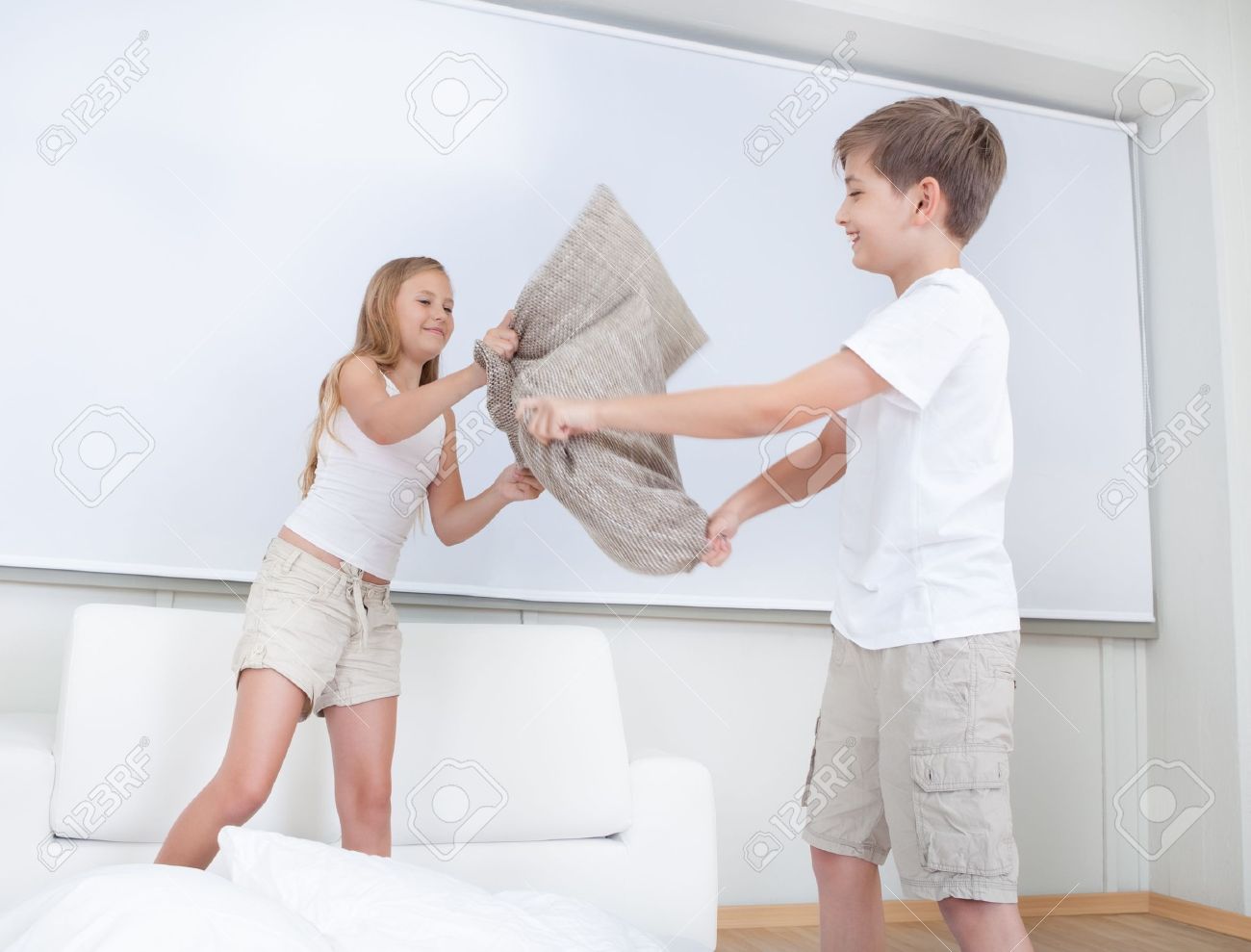 Siblings Having A Pillow Fight Together On Bed In Bedroom Stock Photo,  Picture and Royalty Free Image. Image 15574812., image size:1300x989