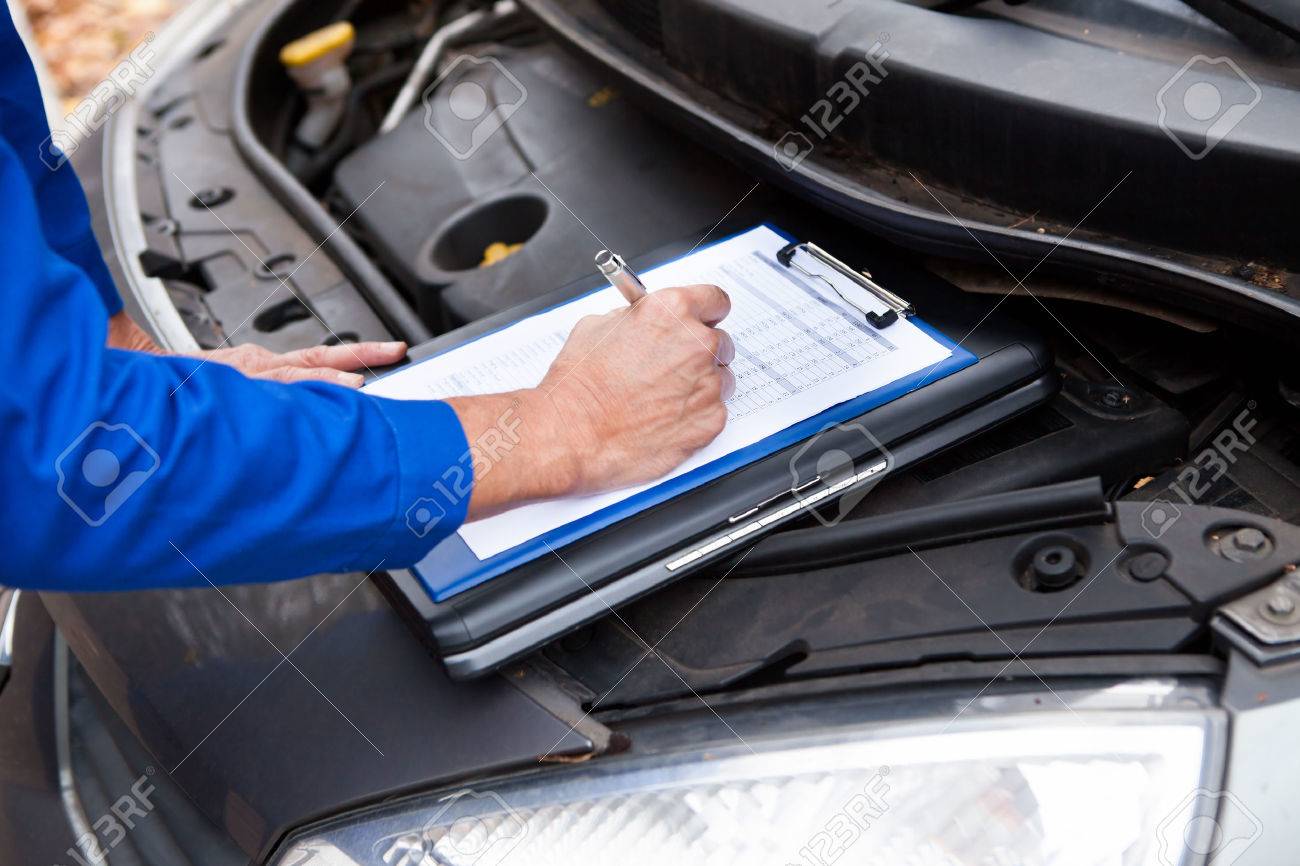 close up of a mature mechanic maintaining car records stock photo automobile records