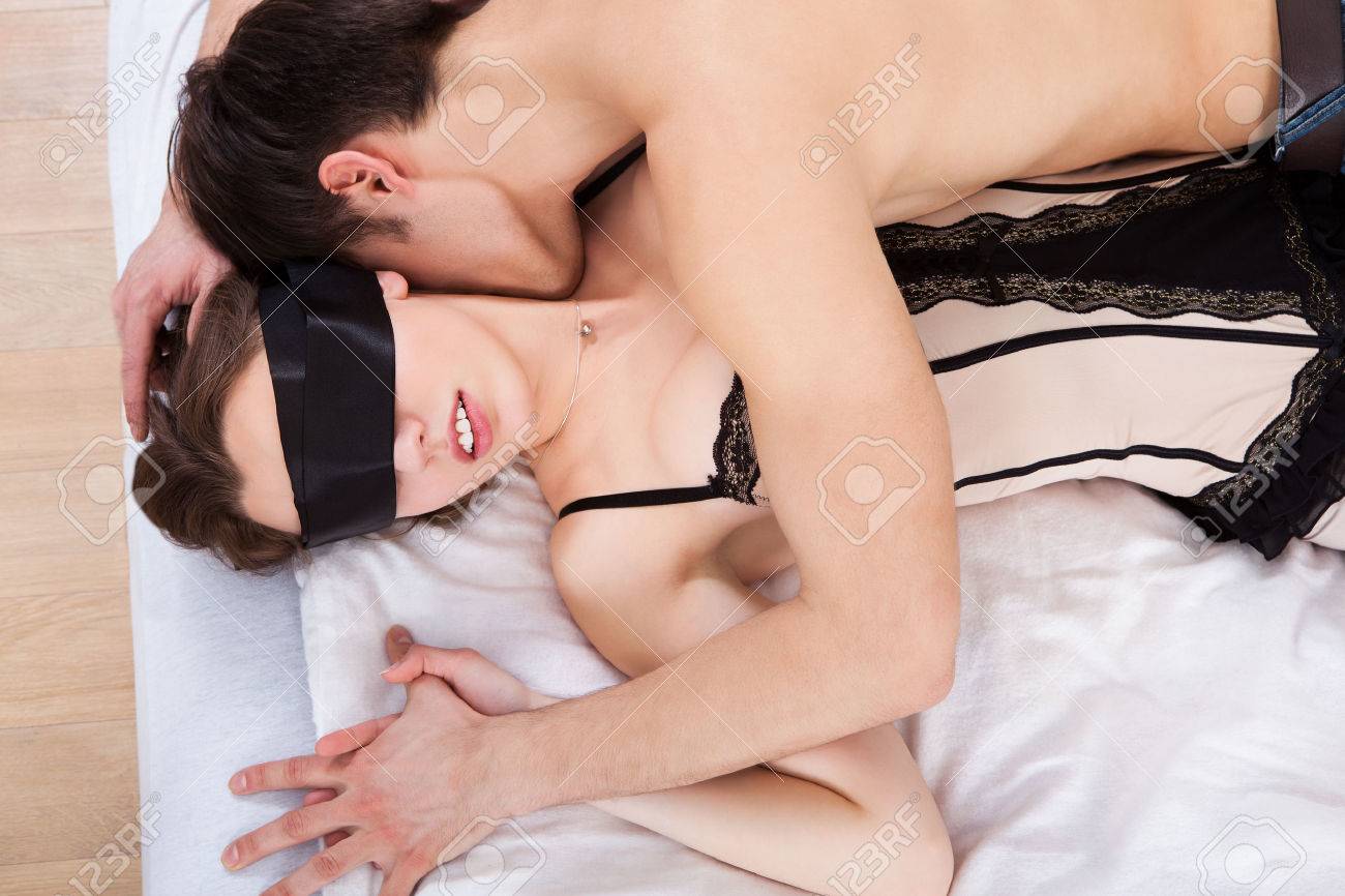 若い男がセクシーなキスの側面図自宅のベッドに女性を目隠し の写真素材 画像素材 Image