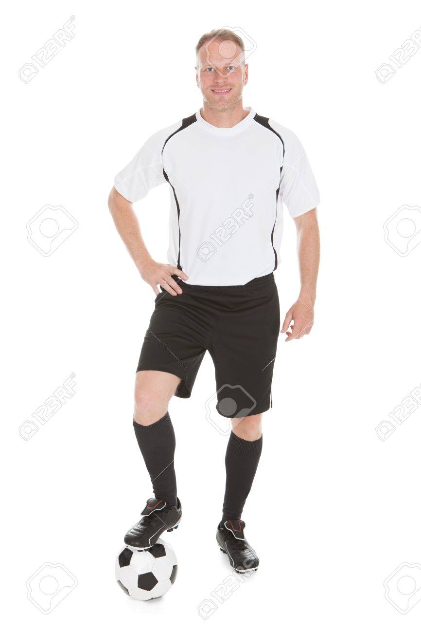 サッカー ボールの白い背景の上に足で自信を持って選手の完全な長さの肖像画 の写真素材 画像素材 Image
