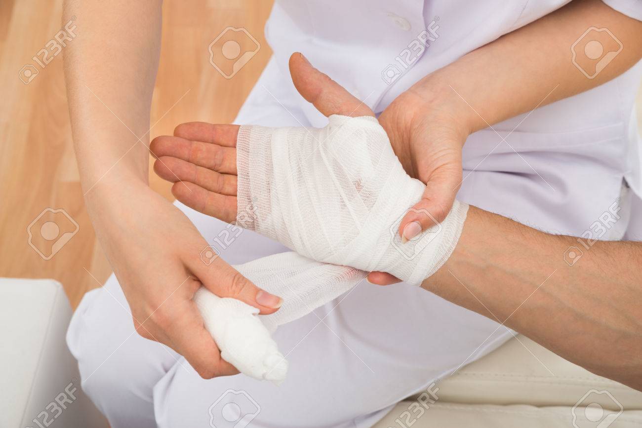 ハイアングル患者さんの手の包帯を巻く女性医師 の写真素材 画像素材 Image