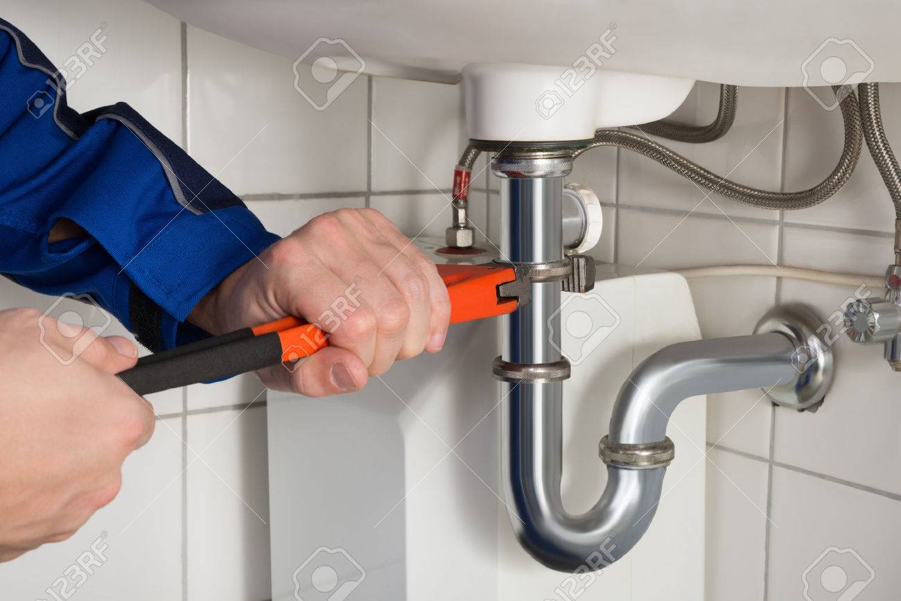 Close-up Of Male Plumber Repairing Sink In Bathroom - 52751279 Close-up Of Male Plumber Repairing Sink In Bathroom - 52751279