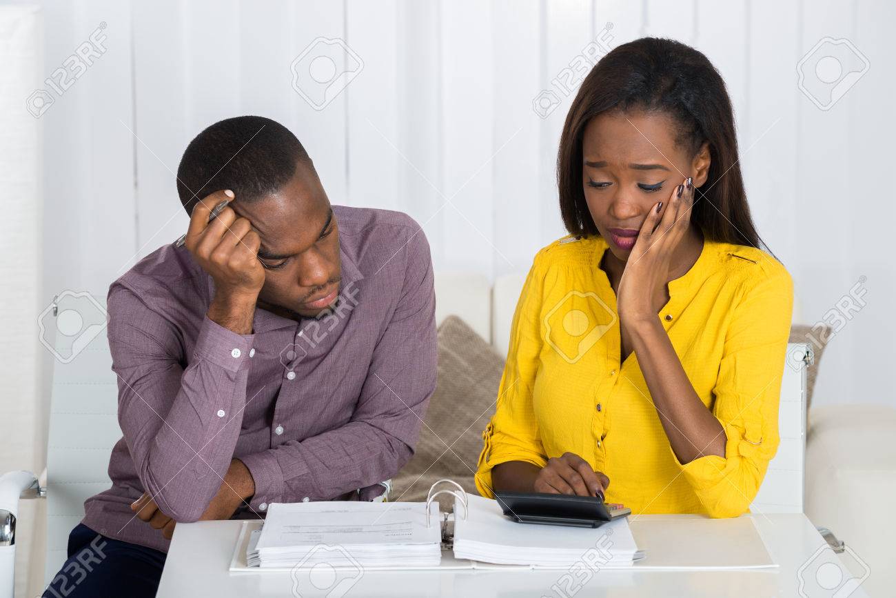 Sad Young African Couple Looking At Bill - 56063946 Sad Young African Couple Looking At Bill - 56063946