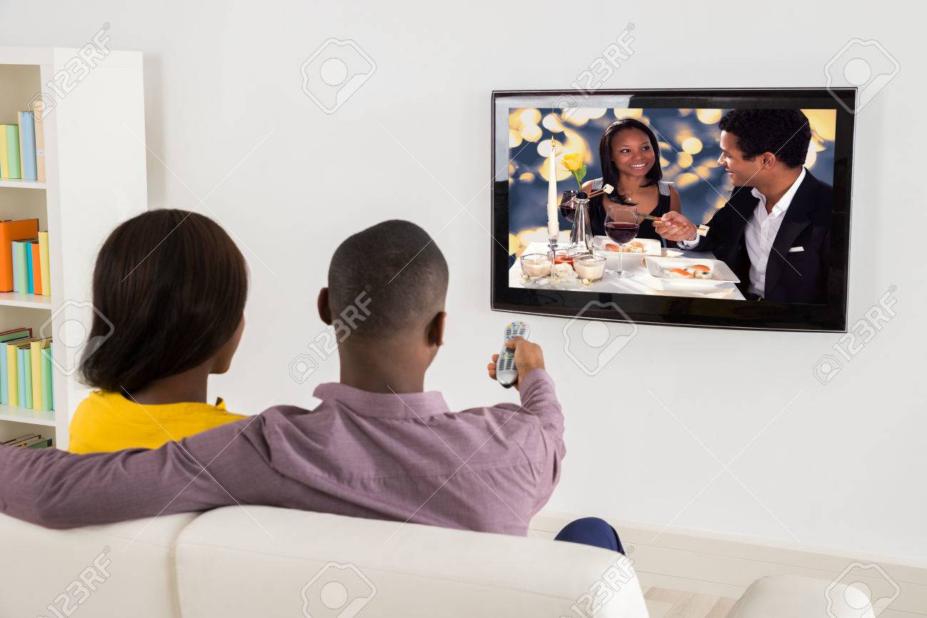 Happy African Couple Watching Television At Home - 56064605 Happy African Couple Watching Television At Home - 56064605
